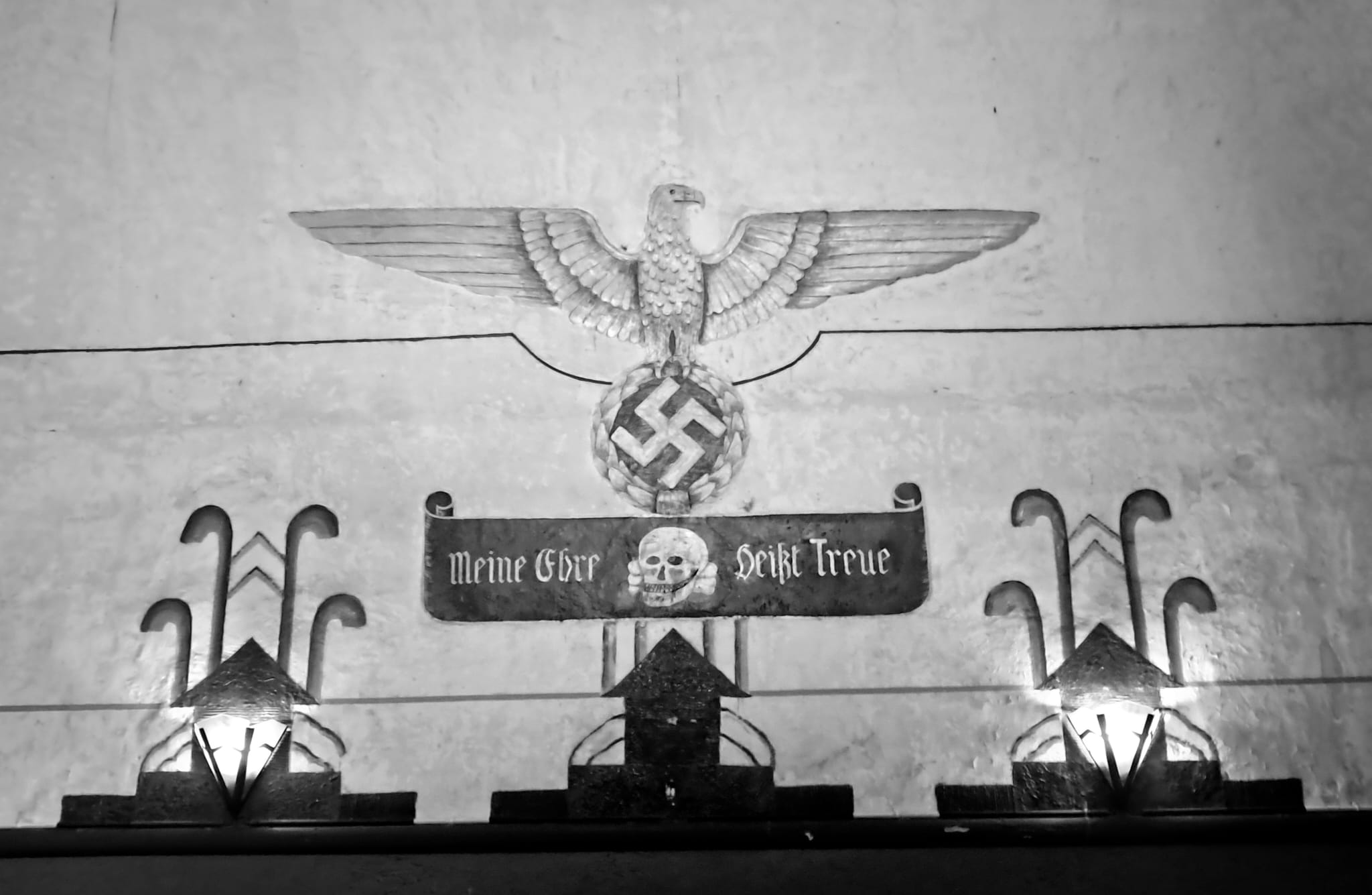 Photo of German troops entering Belgium or the Nazi flag raised over a Belgian building. Represents the sudden shift in power.