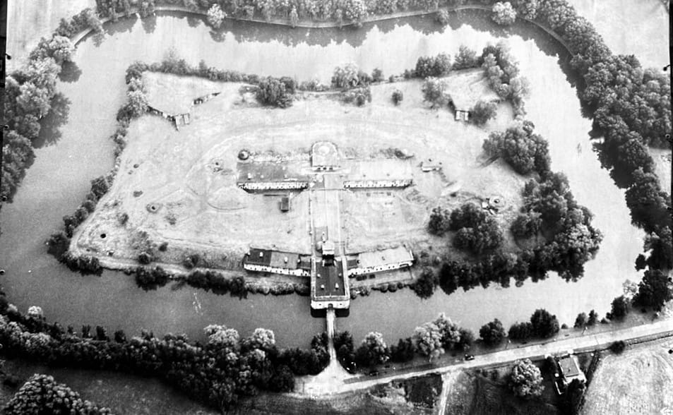 A vintage black and white photo of the fort's construction or early military blueprints. Shows the massive concrete structure intended for defense.