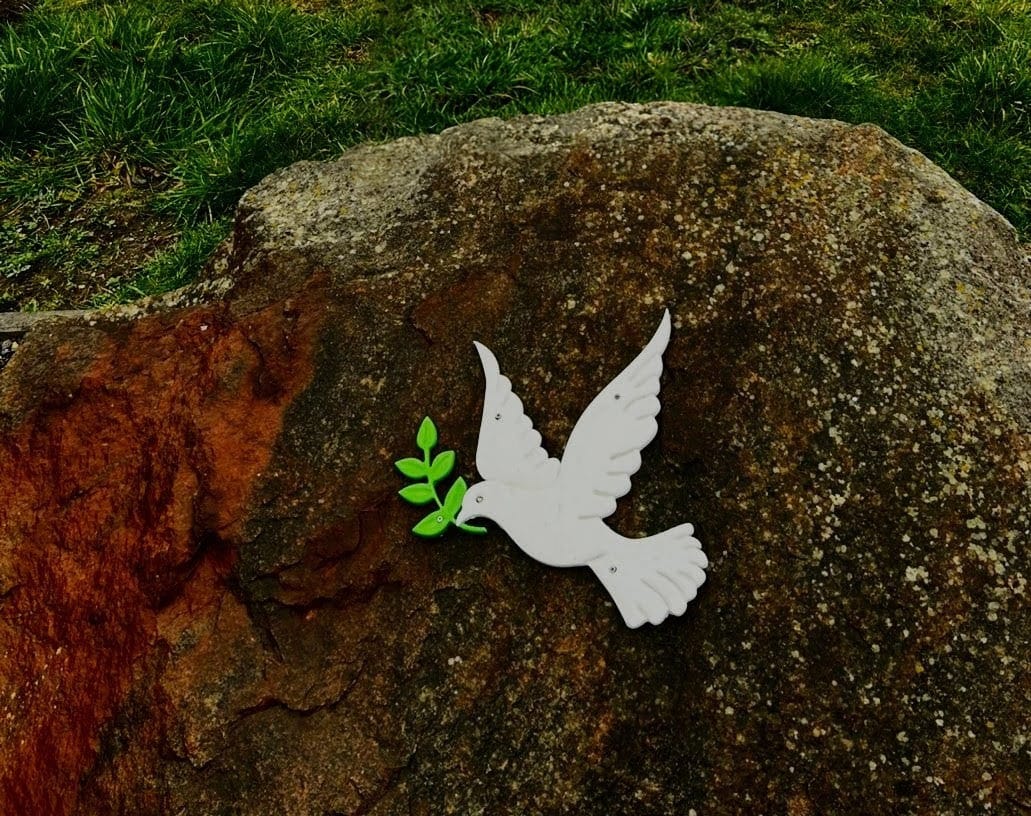 A hopeful image, perhaps a flower growing through concrete or a modern photo of the memorial with sunlight breaking through clouds. Symbolizes hope and resilience.