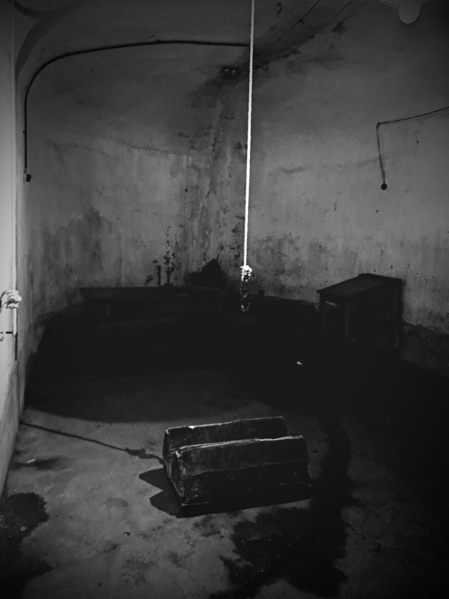 A photo of the torture chamber or the solitary confinement cells. Dark and gritty to convey the horror.